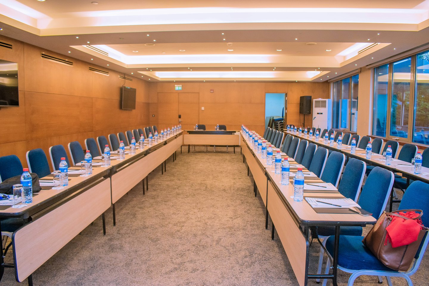Nowoczesna sala konferencyjna z drewnianymi stołami ustawionymi na spotkanie.